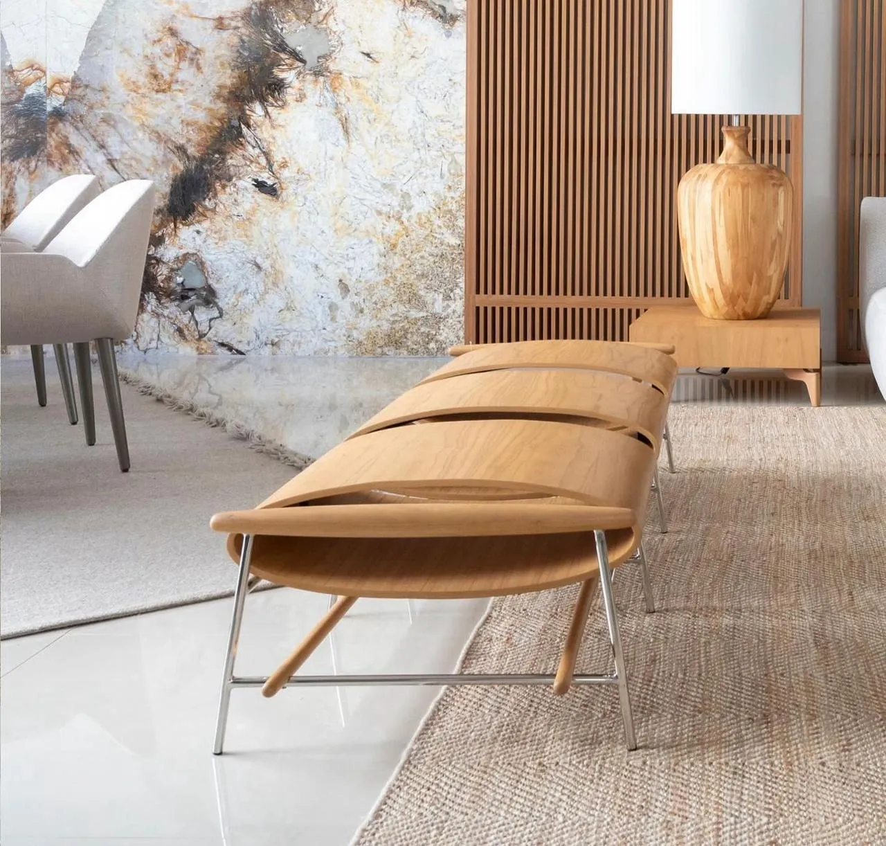Lounge com painel em Mármore Patagonia retroiluminado e mobiliário em madeira clara