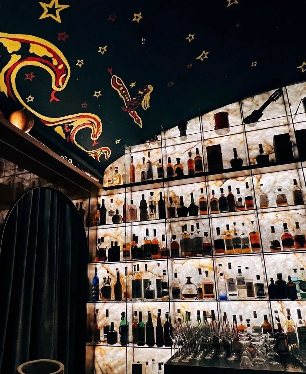 Bar com teto pintado e lareira em rocha clara